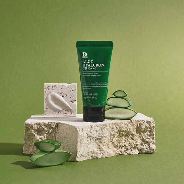Benton Aloe Hyaluron Cream sobre piedra clara con hojas de aloe, sobre fondo verde