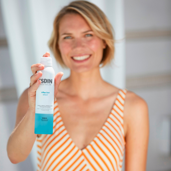 Mujer sosteniendo el After Sun Spray de ISDIN de 200 ml