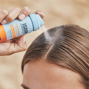 Aplicación del Scalp & Hair Spray SPF 50 de ISDIN sobre la raya del pelo
