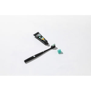 Tubo de Toosty Mint Chocolate junto a un cepillo de dientes negro