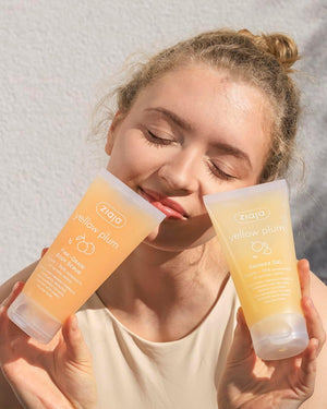 Modelo con el exfoliante corporal y el gel de ducha Ziaja Juicy Yellow Plum